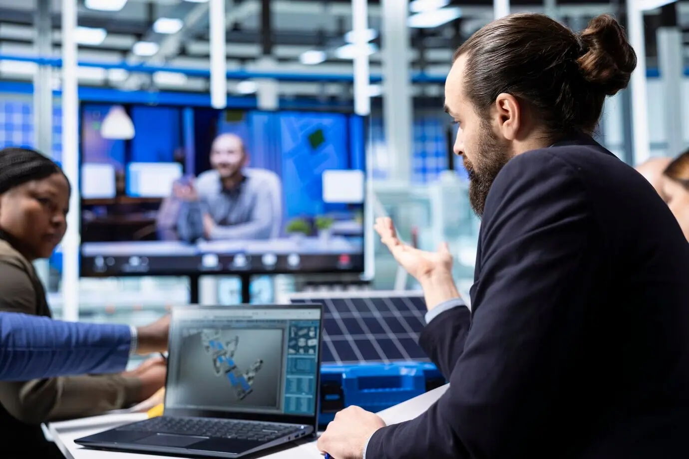 Менеджеры промышленного завода рассматривают CAD-симуляции во время удалённой видеоконференции.